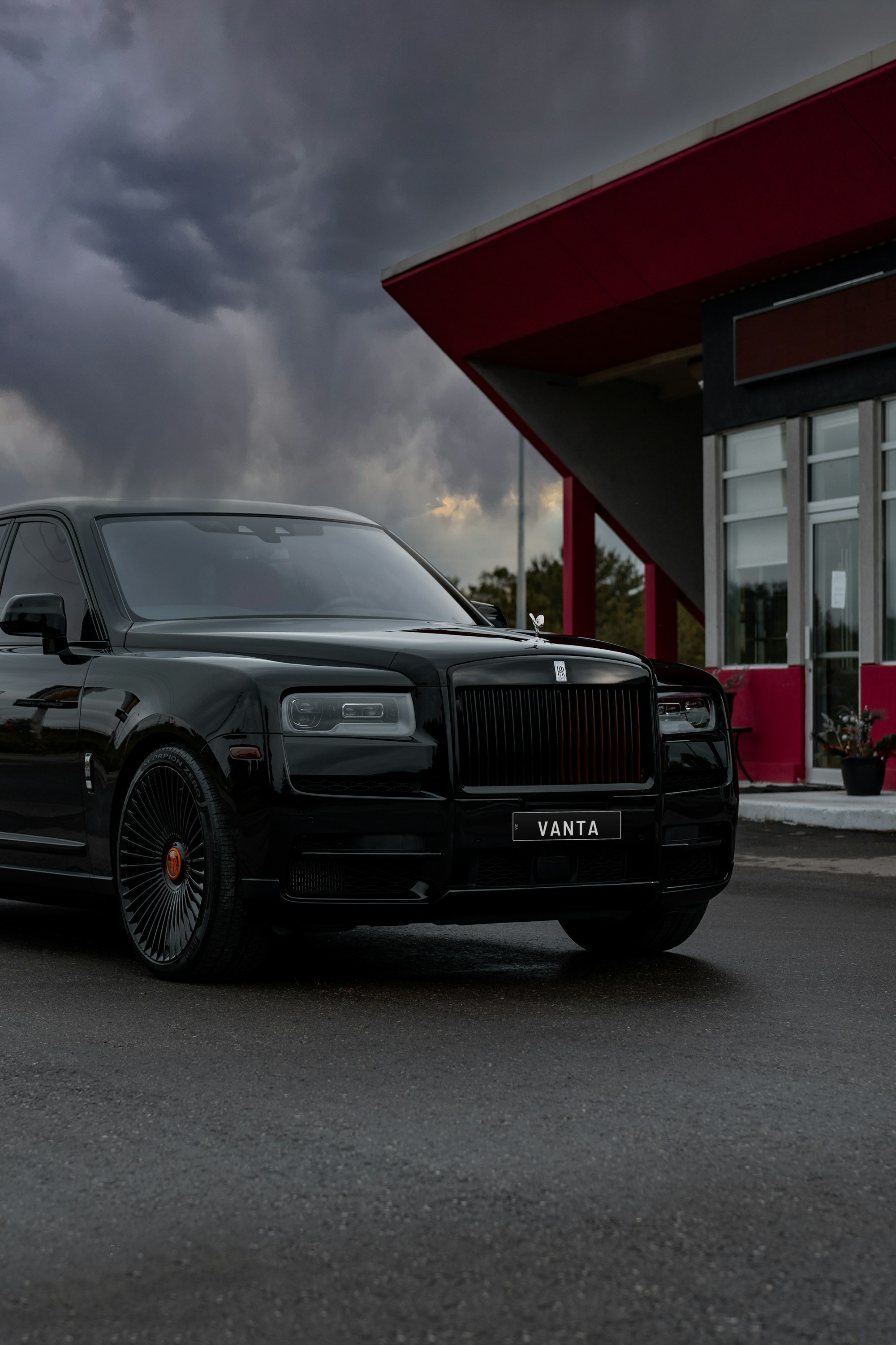 Black Rolls-Royce Cullinan parked outside a modern building